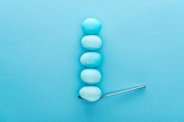 top view of blue easter eggs on spoon isolated on blue  - Photo, Image