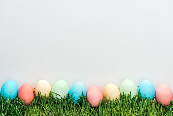 top view of traditional easter eggs on grass isolated on grey  - Photo, Image