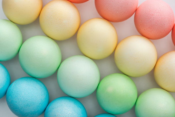 top view of colorful painted easter eggs on grey - Fotoğraf, Görsel