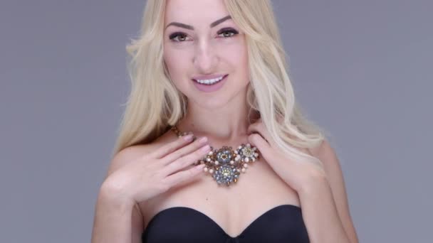 Beautiful woman posing in studio. She shows womens jewelry - Footage, Video