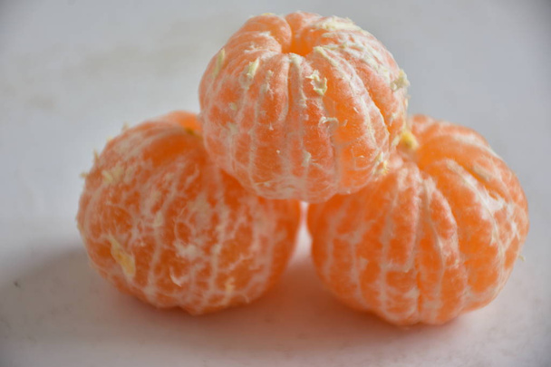 Oříznutý pohled na oloupané mandarinky na bílém stole - Fotografie, Obrázek