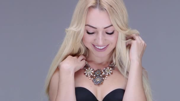 Beautiful woman posing in studio. She shows womens jewelry - Footage, Video