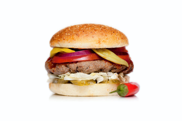 Ζουμερά burger με ένα μεγάλο μπιφτέκι, τυρί, αγγούρι, ντομάτα, κρεμμύδι, λάχανο, σως και σουσάμι κουλούρι σε λευκό φόντο - Φωτογραφία, εικόνα
