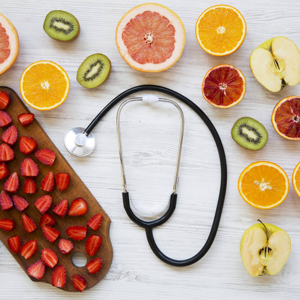 Assortimento di vari frutti colorati con stetoscopio sopra whit
 - Foto, immagini