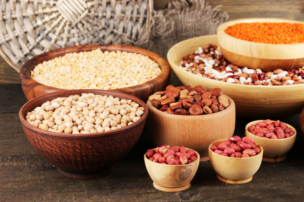 Different kinds of beans in bowls on wooden background - Fotoğraf, Görsel