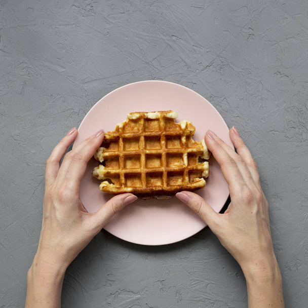 Üstten Görünüm, geleneksel Belçika waffle iğnesi üzerinde tutan eller - Fotoğraf, Görsel