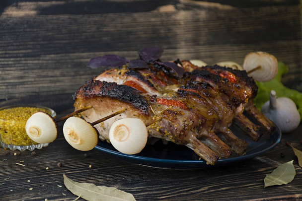 Costillas de cerdo a la parrilla con verduras y especias sobre fondo de madera. Vista lateral
. - Foto, Imagen