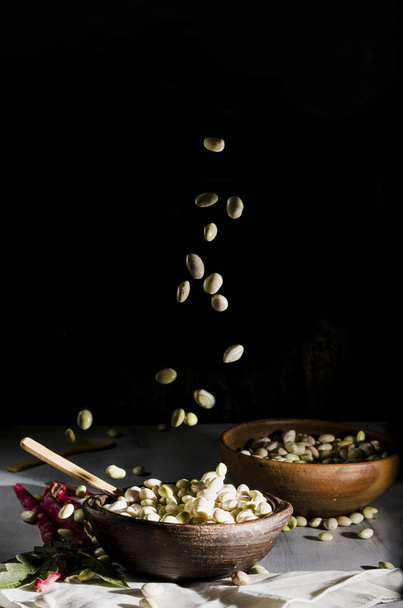 frijoles blancos en una olla de arcilla, en la técnica de alimentos oscuros, comida típica
 - Foto, imagen