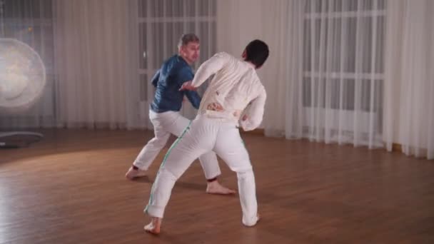 Capoeira. Dwóch młodych mężczyzn, szkolenia w studio w nocy - Materiał filmowy, wideo