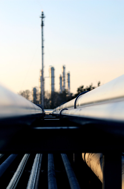 Длинная труба и силуэт нефтеперерабатывающего завода
 - Фото, изображение