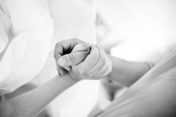 Marido segura a mão de sua esposa no hospital
 - Foto, Imagem