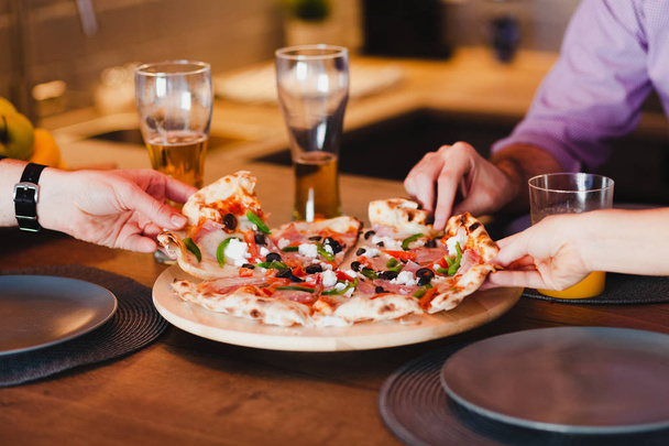 Freunde essen Pizza am Tisch - Foto, Bild