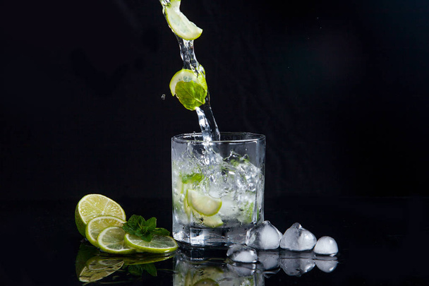 Summer cocktail mojito with splash on black background - Photo, image