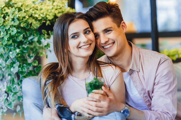 Young beautiful couple drinking cocktail on summer terrace - Photo, image
