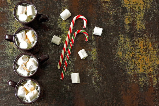 Hot drink with white marshmallows. Christmas hooks on a stylish shabby surface. Stylish Christmas arrangement with white marshmallow, hot chocolate drink and Christmas hooks. - Фото, изображение