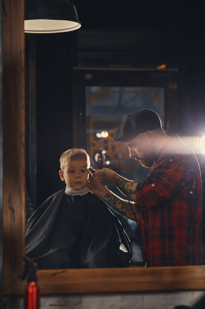 Valkoihoinen poika kampauksen parturissa sisätiloissa
 - Valokuva, kuva