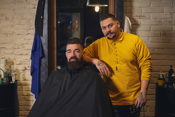 理髪店で髭剃り中に大きな黒ひげを持つクライアント - 写真・画像