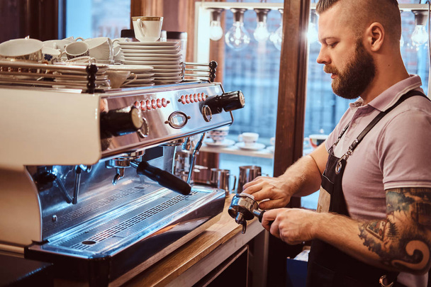 Boční pohled barista čistí portafilter před přípravou cappuccina v kavárně - Fotografie, Obrázek