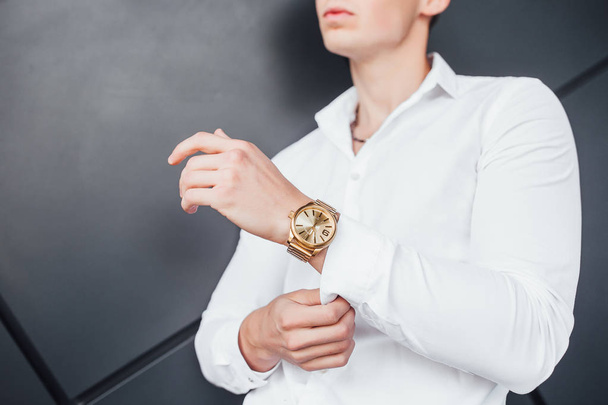 Expensive gold watch on hand of businessman in white shirt, cropped view - Fotó, kép
