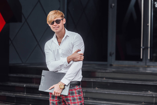 man in sunglasses and white shirt holding folder and smiling - Фото, зображення