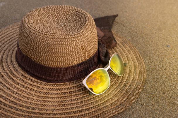 női kalap és napszemüveg a homok a tengerparton, utazási koncepció - Fotó, kép