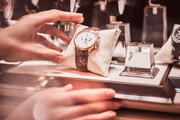 Γκρο πλαν του χεριού τους πωλητές δείχνει το αποκλειστικό mens ρολόι από τη νέα συλλογή - Φωτογραφία, εικόνα