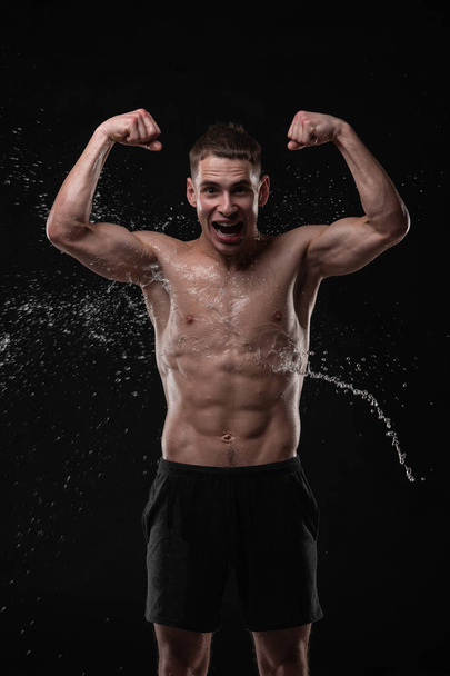 Handsome young man posing with water splashes on face and chest in Studio shot - Fotografie, Obrázek