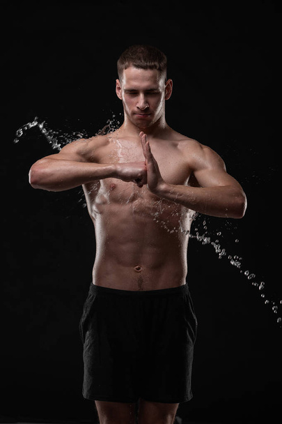 Handsome young man posing with water splashes on face and chest in Studio shot - Fotografie, Obrázek