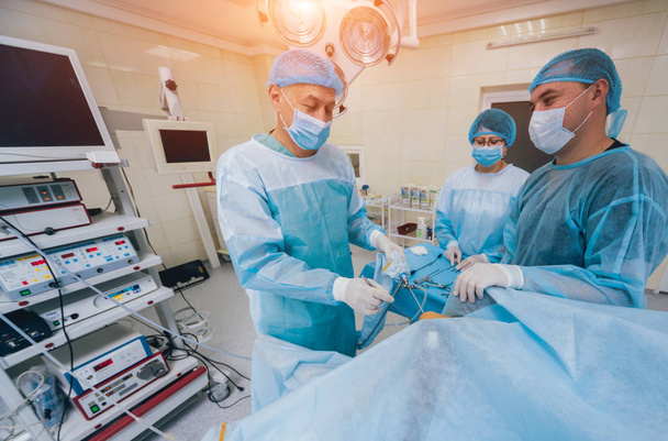 Arthroscope surgery. Orthopedic surgeons in teamwork in the operating room with modern arthroscopic tools. Knee surgery. Hospital background - Foto, Imagen