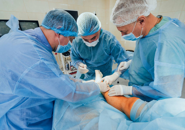 Διαδικασία της τραύμα χειρουργικής επέμβασης. Ομάδα χειρουργών στο λειτουργικό δωμάτιο με εξοπλισμό χειρουργική επέμβαση. Ιατρικό ιστορικό - Φωτογραφία, εικόνα