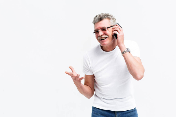 Happy smiling man speaking on smartphone and posing at camera isolated on white background - Photo, image