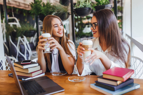 Two businesswomen drinking latte at lunch after hard work  - Fotoğraf, Görsel