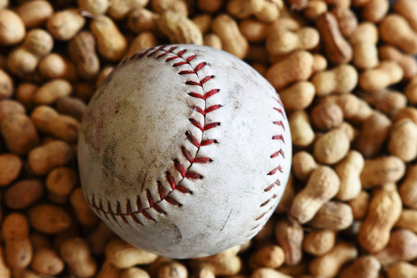 Крупним планом зображення старого шкіряного бейсболу та смажених горіхів
.  - Фото, зображення