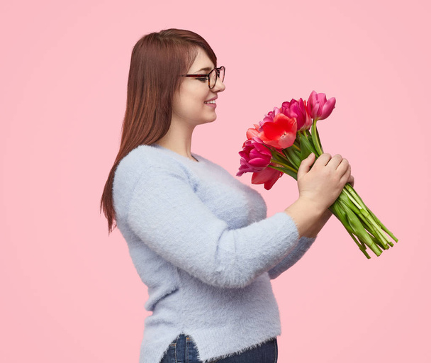 Romantic plump girl with presented flowers  - Foto, Imagen
