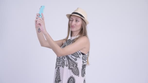 Portrait of happy blonde tourist woman taking selfie - Filmati, video