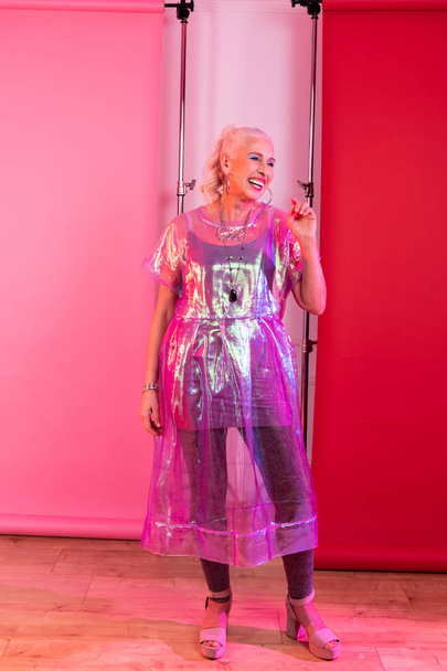 Positive delighted blonde female demonstrating modern clothes - Valokuva, kuva