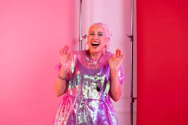 Pleased mature model laughing while shooting in studio - Fotó, kép