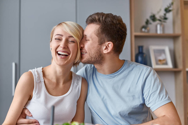 Young man hugging laughing woman at home - Fotoğraf, Görsel