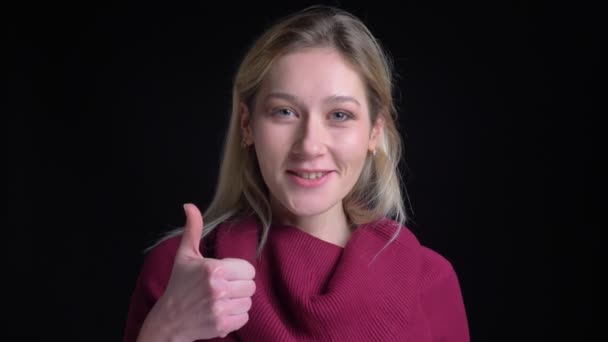 Close-up schieten van mooie Kaukasische vrouwelijke lsmiling en toont een duim omhoog terwijl u naar de camera - Video