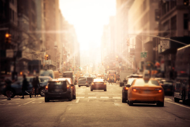 defokussierte Unschärfe entlang der geschäftigen New Yorker City Street in Midtown Manhattan mit Autos und anonymen Menschen mit Sonnenlicht - Foto, Bild