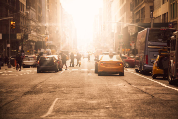 Defocused blur along busy New York City street in midtown Manhattan with cars and anonymous people with sunlight - Foto, Bild