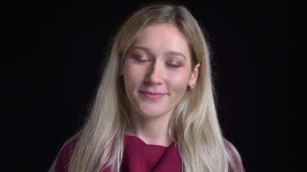 Střílejí mladé bělošské blonďaté ženy v klidu a usmívající se v pozadí izolovaně na černém - Záběry, video