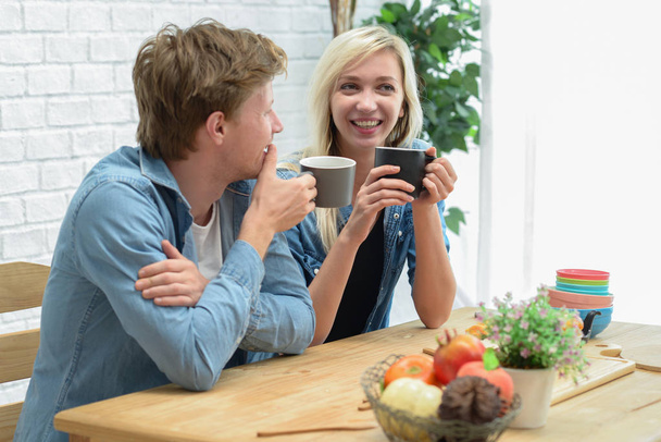 glückliches Paar bei Kaffeepause und Dessert in der weißen Küche - Foto, Bild