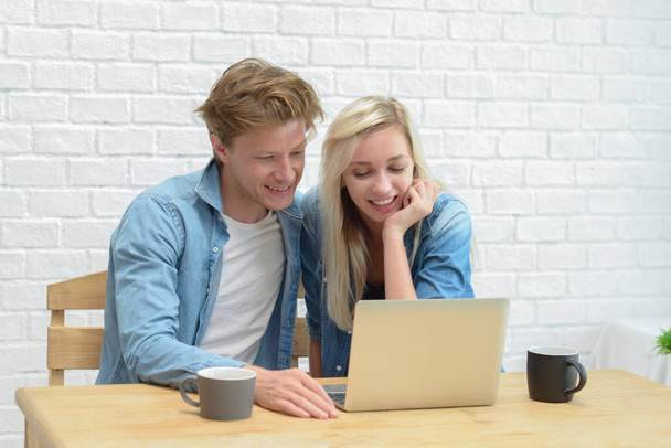 Young couple managing their family budget, sitting on the white  - Photo, Image