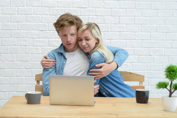 Young couple managing their family budget, sitting on the white  - Photo, image