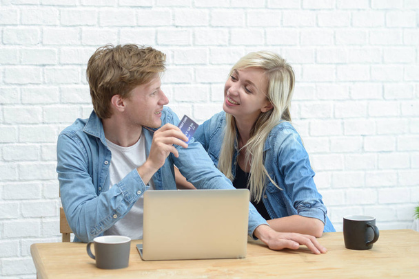 Retrato de una alegre pareja de compras en línea con el ordenador portátil comput
 - Foto, imagen