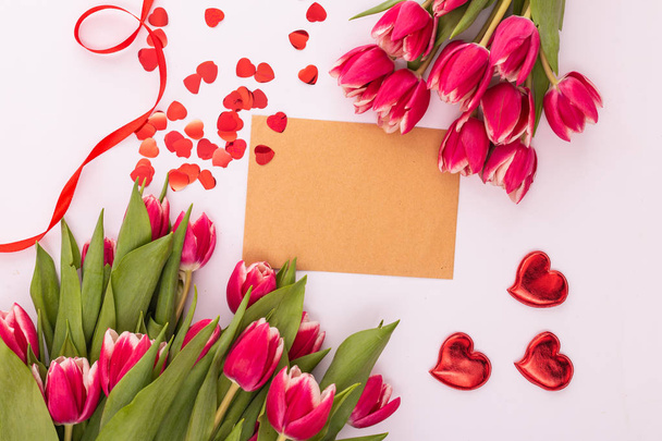 Vaaleanpunaiset tulppaanit ja valkoinen tyhjä teksti valkoisella taustalla. Ystävänpäivän, naistenpäivän tai äitienpäivän tervehdyskortti
 - Valokuva, kuva