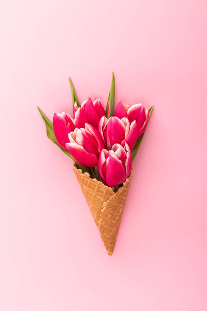 Pink tulip Cup wafel na białym tle na różowym tle. Z życzeniami na Walentynki, dzień kobiet czy dzień matki. Koncepcja wiosna. - Zdjęcie, obraz