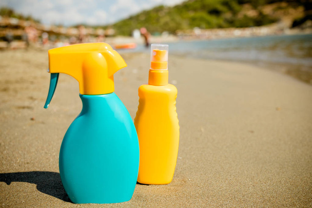 Пляшка сонцезахисного крему на піщаному пляжі. Композиція з засобами захисту від сонця. Пляшка, що відштовхується від комарів, розбризкує тіло, купається на пляжі, літні канікули. Простір для копіювання
 - Фото, зображення