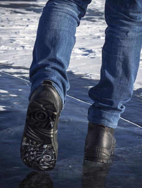 Las piernas del hombre en negro caminando en la nieve
 - Foto, imagen